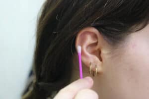 Cleaning a pierced ear with a q tip