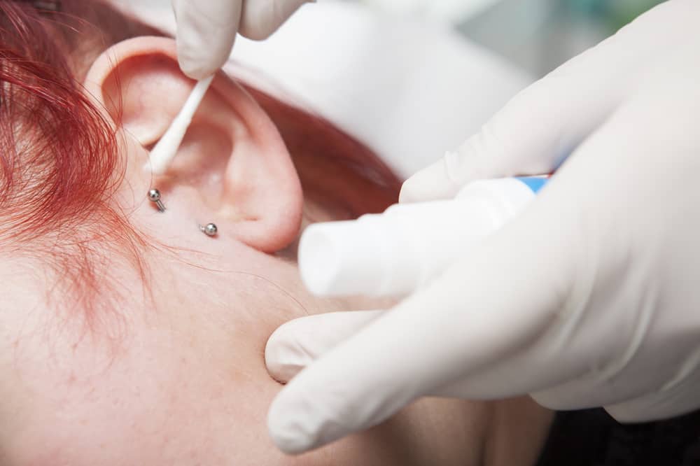 Cleaning an ear piercing with a q tip